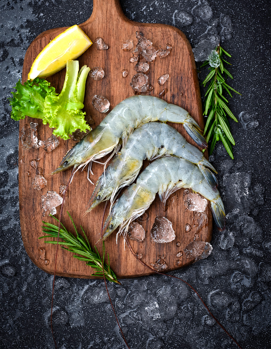 Raw vannamei white shrimp on dark wet slate