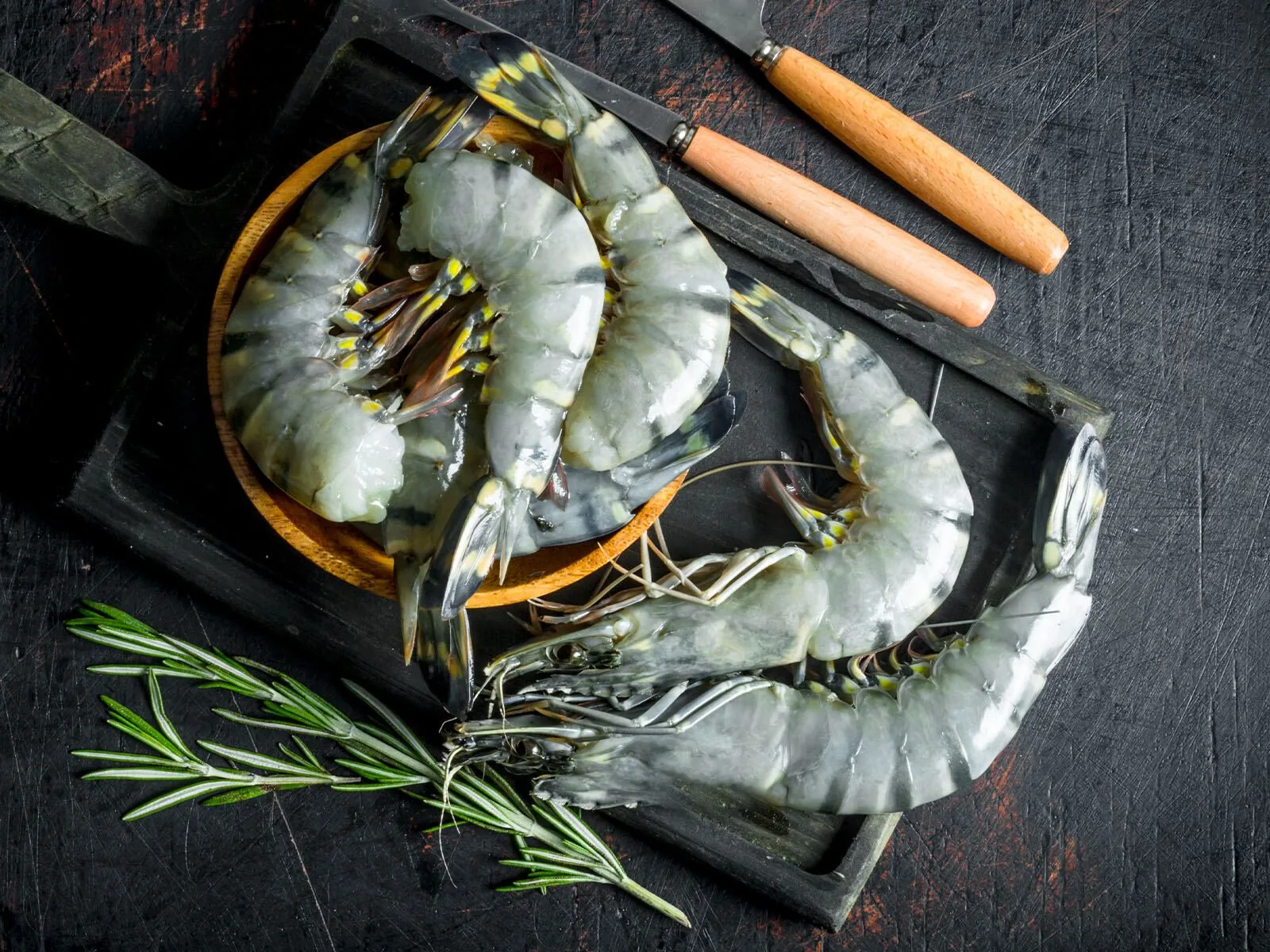 Raw black tiger shrimp on dark stone