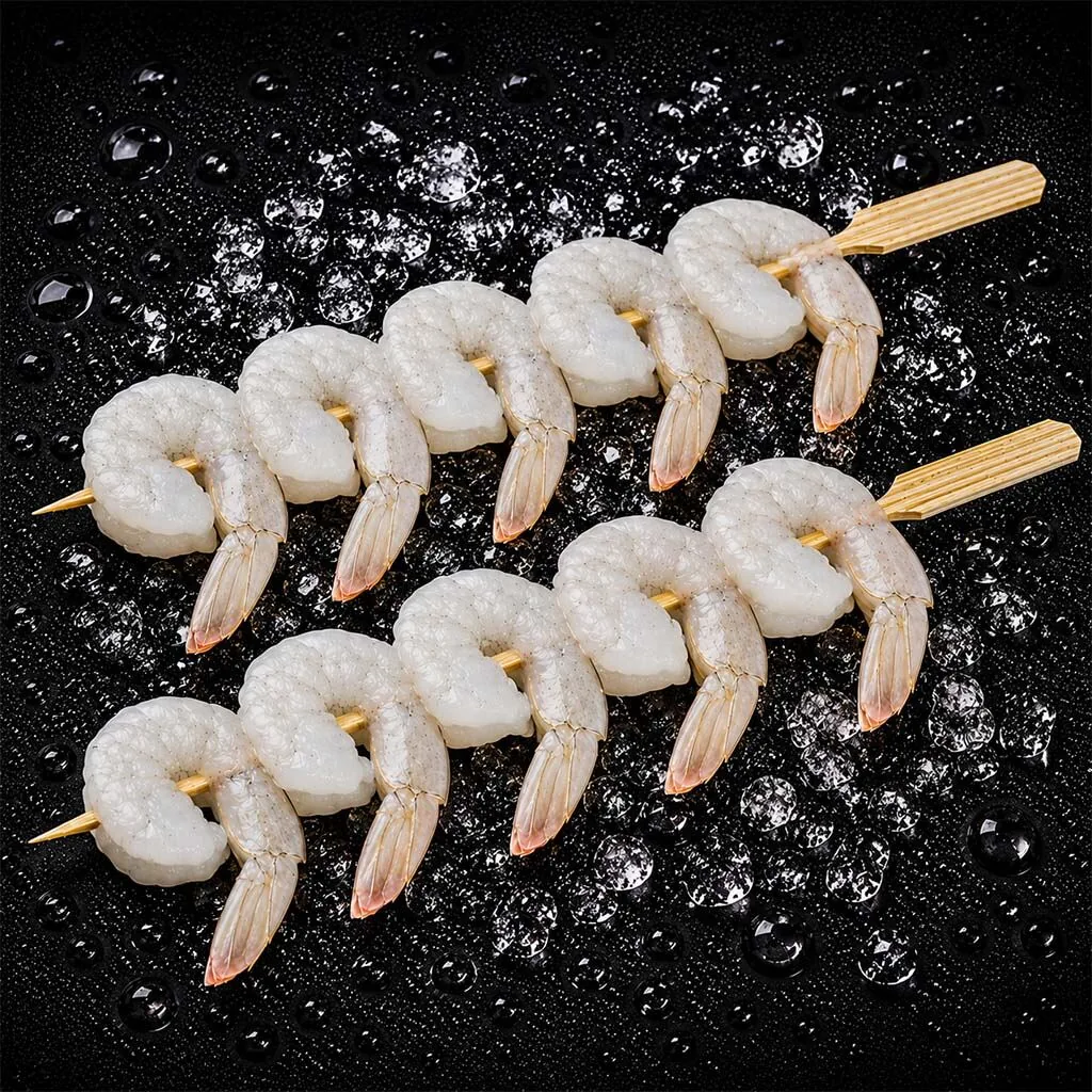 Grilled shrimp skewers on dark slate